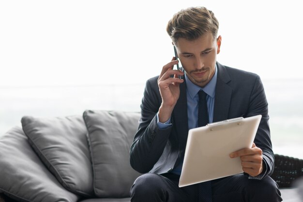 El éxito de hombre joven Hablar de negocios en el teléfono