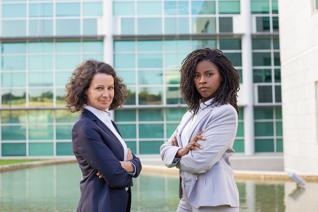 Foto gratuita la exitosa mezcla femenina compitió con socios comerciales posando afuera