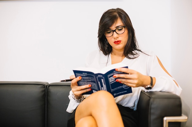 Exitosa mujer con un libro serio en la oficina