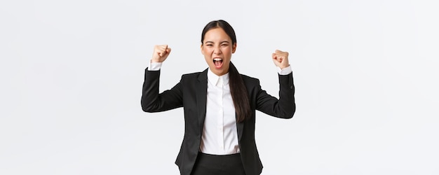 Exitosa mujer de negocios ganadora bombeando el puño y gritando sí de felicidad y encantada de lograr goa