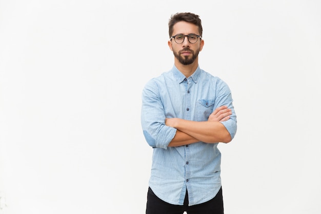 Exitoso empresario masculino confiado posando con los brazos cruzados