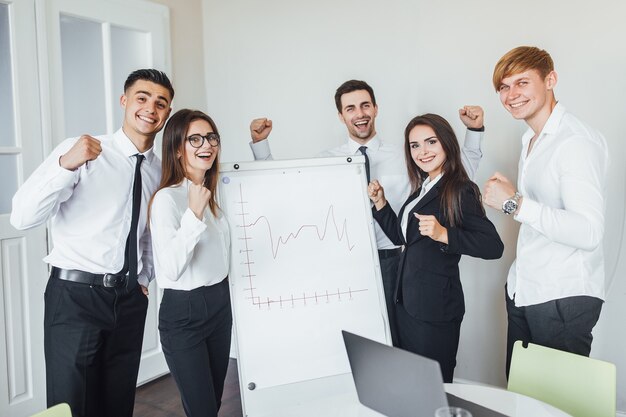 Exitoso equipo de jóvenes empresarios de perspectiva en la oficina después de una reunión de negocios