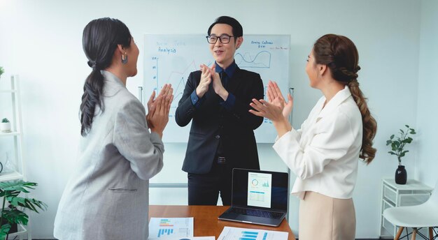 El exitoso equipo de negocios está aplaudiendo la celebración de los empresarios asiáticos durante la reunión