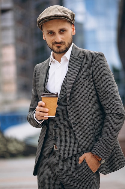 Exitoso hombre de negocios por el rascacielos tomando café