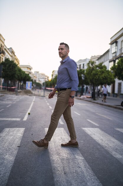 Exitoso joven empresario caminando por la calle durante el día