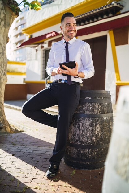 Exitoso joven empresario con un traje formal usando una tableta