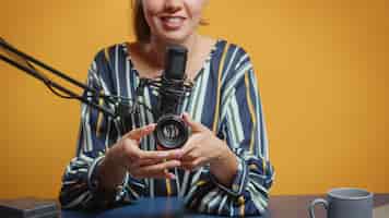 Foto gratuita experta en fotografía hablando sobre lentes de cámara en su podcast semanal para suscriptores. creador de contenido, influenciador estrella de los nuevos medios en las redes sociales, hablando, equipo de fotos de video para un programa web en línea