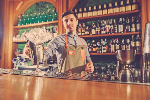 El experto barman prepara cócteles en un club nocturno.