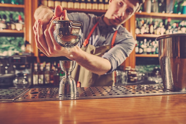 El experto barman prepara cócteles en un club nocturno.