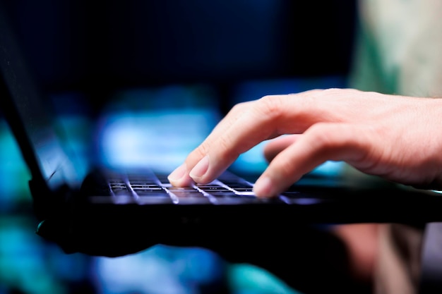 Experto en granja de servidores que utiliza computadora portátil para trabajar con datos esenciales para entrenar modelos de aprendizaje automático que alimentan sistemas de inteligencia artificial que requieren almacenamiento y alta potencia de computación, de cerca