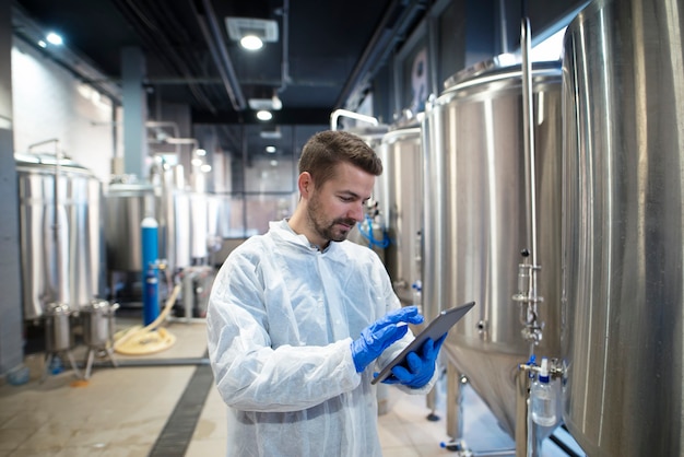 Experto en tecnología con tablet PC en la línea de producción de la fábrica de alimentos