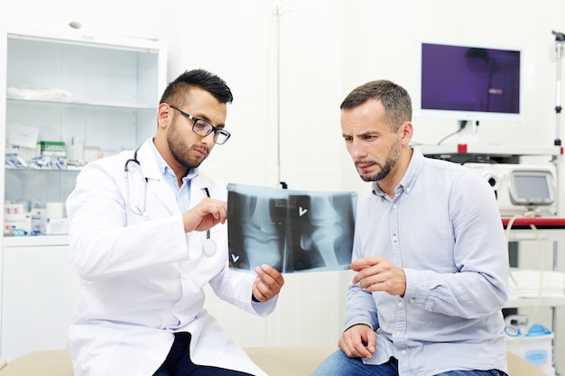 Foto gratuita explicar los resultados de las radiografías al paciente.