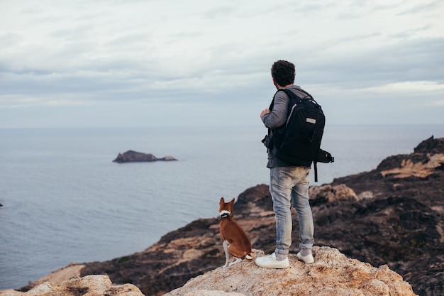 Explorador urbano o aventurero se encuentra en la cima de la montaña con su mejor amigo