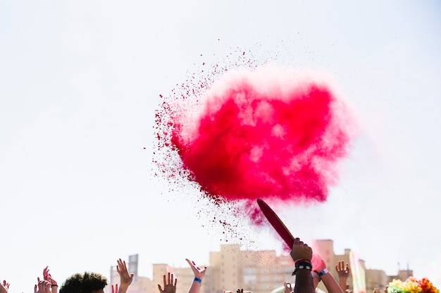 Explosión de color rojo holi sobre la multitud