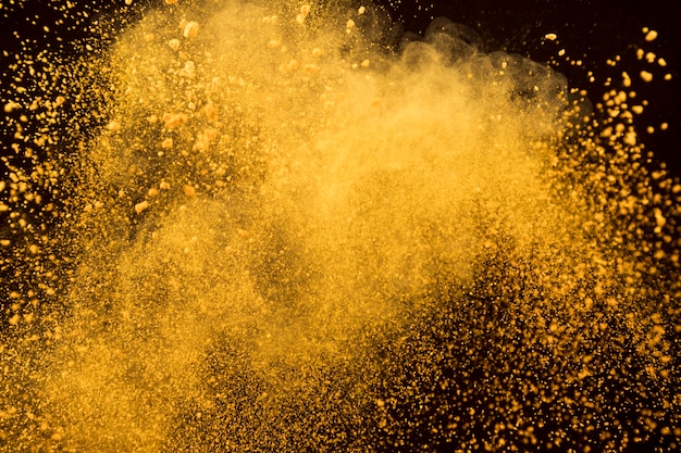 Explosión de naranja de polvo cosmético sobre fondo oscuro