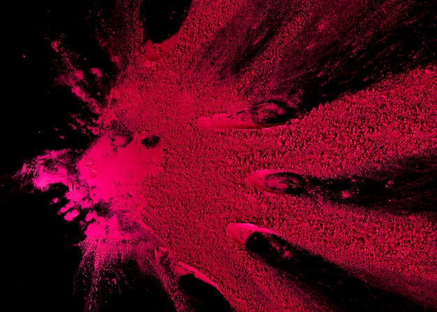 Foto gratuita explosión de polvo de color rosa abstracta sobre fondo negro