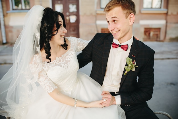 Expresiva joven pareja en trajes de boda