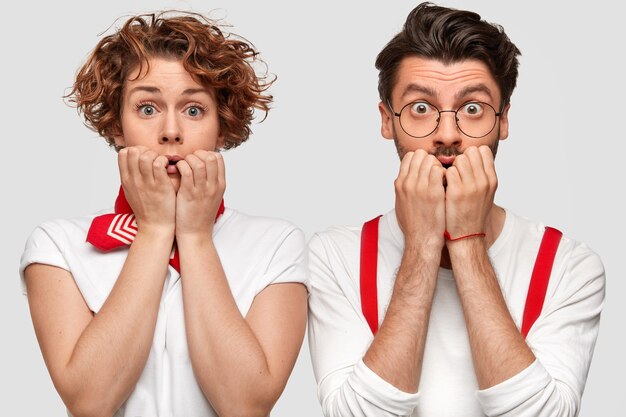 Expresivo hombre y mujer en camisetas blancas posando