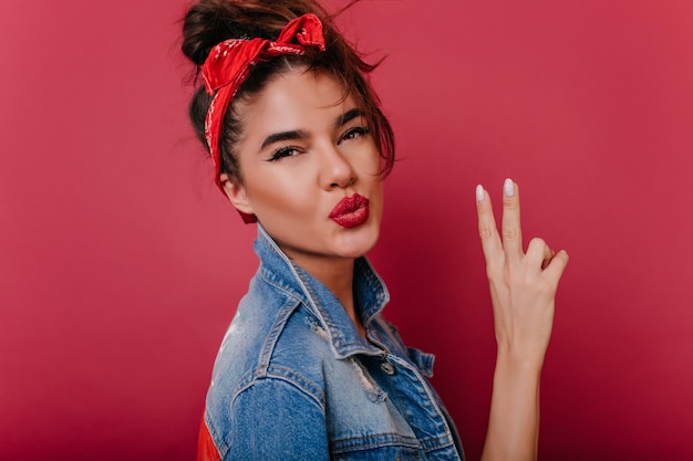 Foto gratuita extasiada mujer joven en traje vintage posando con expresión de cara de besos en el espacio clarete