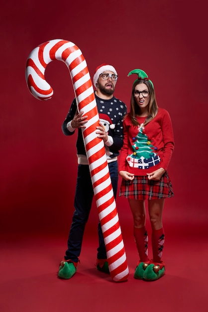 Extraña pareja de Navidad con bastón de caramelo