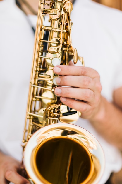 Extremo de cerca saxofón tocado por el músico