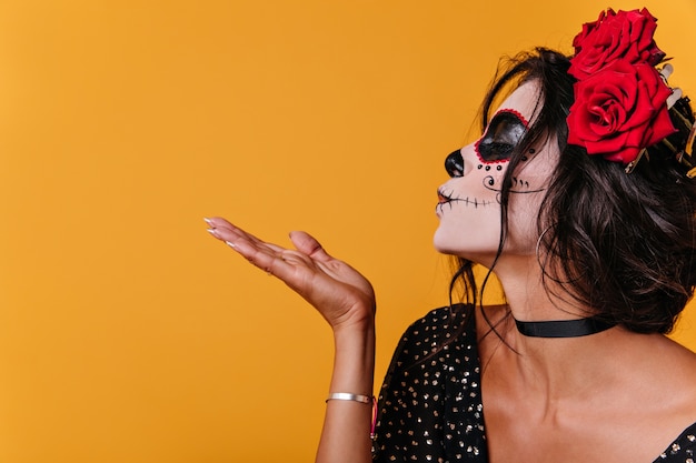 ÃƒÂ'lose-up shot de chica de perfil. Señora con maquillaje no estándar al festival envía beso al aire