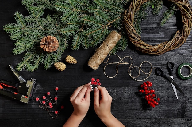 Fabricante de decoración navideña con sus propias manos. Corona de Navidad para las vacaciones. La celebración del año nuevo. Vista superior