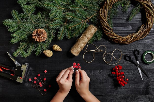 Fabricante de decoración navideña con sus propias manos. Corona de Navidad para las vacaciones. La celebración del año nuevo. Vista superior