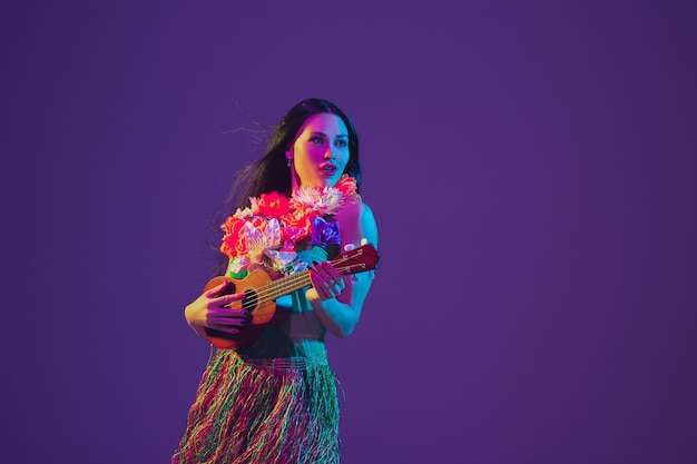 Fabulosa bailarina del Cinco de Mayo en la pared púrpura del estudio en luz de neón