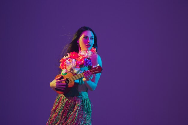 Fabulosa bailarina del Cinco de Mayo en la pared púrpura del estudio en luz de neón