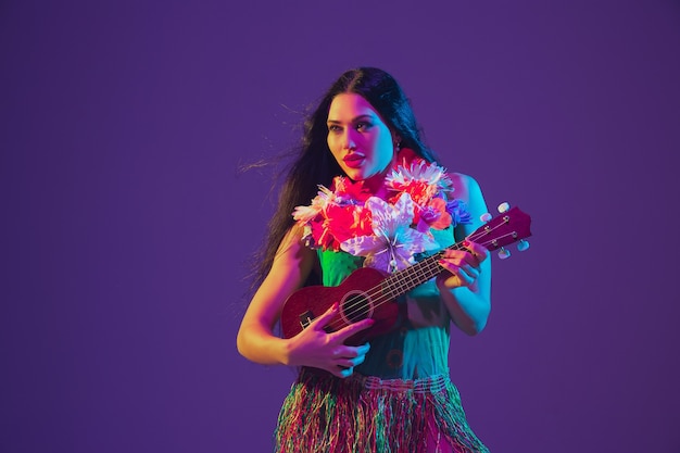 Fabulosa bailarina del Cinco de Mayo en la pared púrpura del estudio en luz de neón