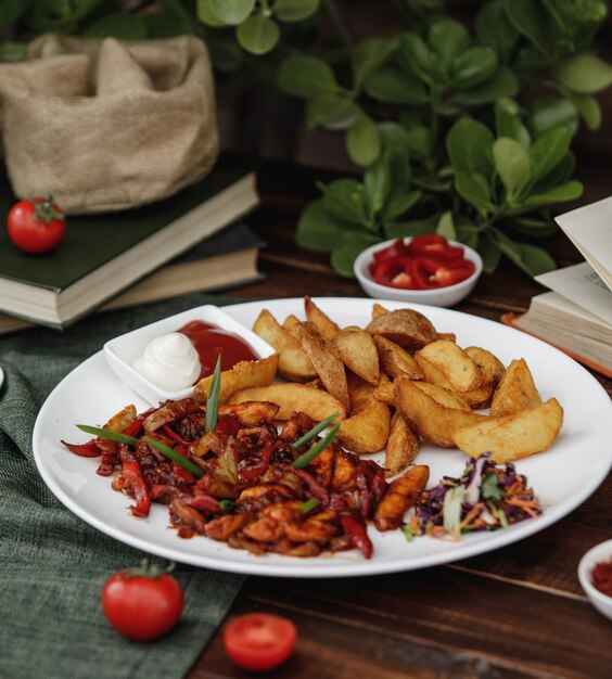 Fajitas de pollo a la mexicana con papas asadas servidas con salsas y ensalada