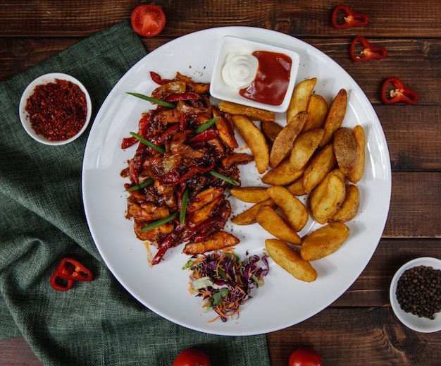 Fajitas de pollo con papas asadas servidas con salsas y ensalada