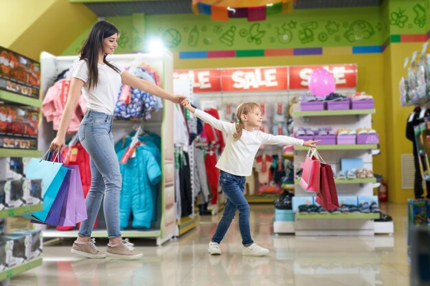 Familia activa manteniendo bolsas de papel y corriendo en la tienda