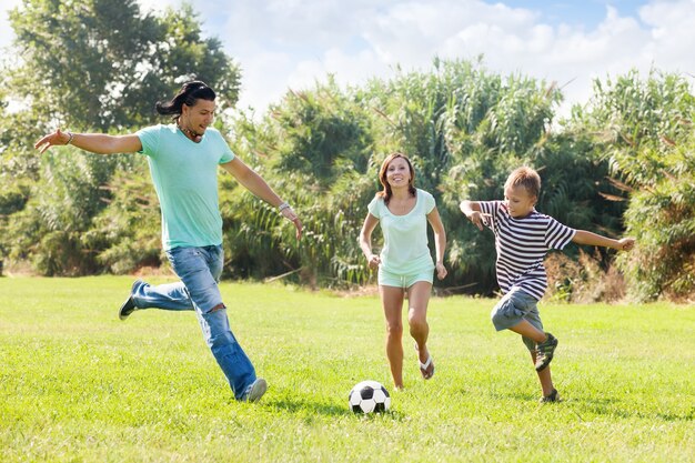 Familia con adolescente jugando en el fútbol