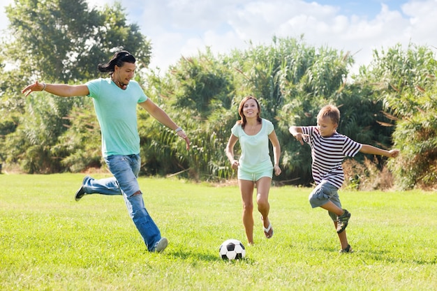 Familia con adolescente jugando en el fútbol