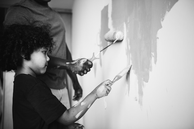 Familia africana pintando la pared de la casa