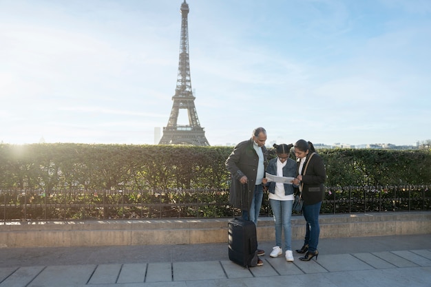 Familia afroamericana mirando el mapa en su viaje a parís