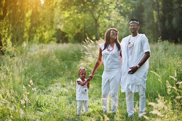 Familia afroamericana en vestido nacional nigeriano blanco divirtiéndose al aire libre