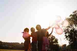 Foto gratuita familia agitando las manos con globos