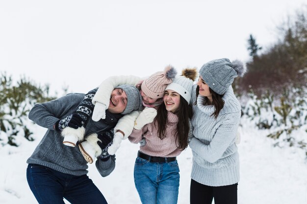 Familia alegre abrazando en el campo de invierno
