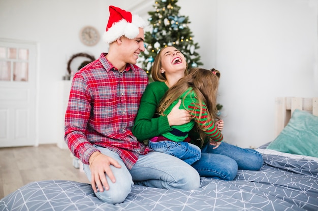 Familia alegre en la cama en navidad