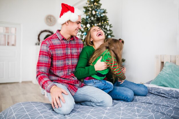 Familia alegre en la cama en navidad