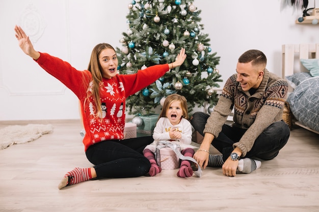 Familia alegre celebrando navidad en casa