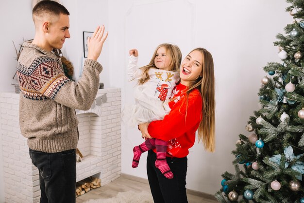Familia alegre celebrando navidad en casa