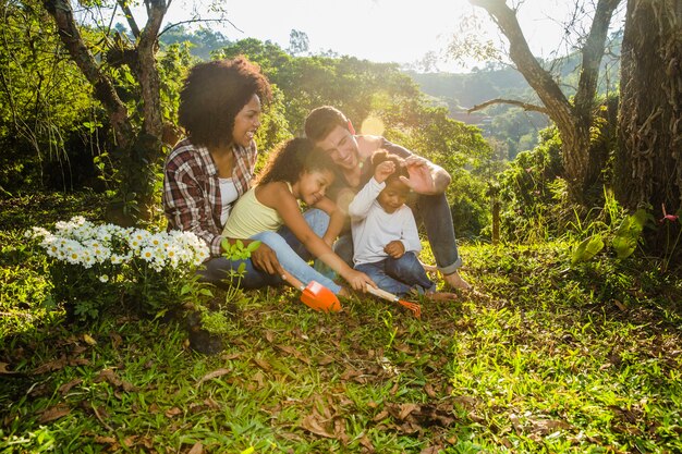 Familia alegre sentada en el césped