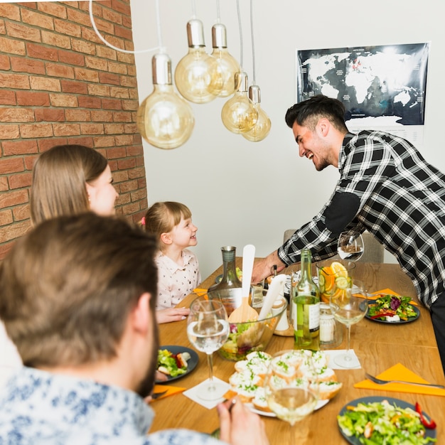 Familia alegre sentada en la mesa