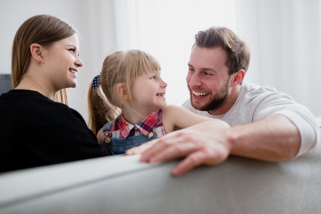 Familia alegre sentada en el sofá