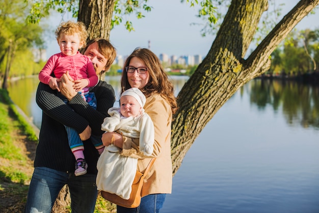 Foto gratuita familia alegre con sus hijos junto al lago