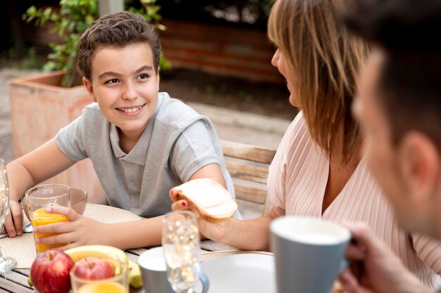 Familia almorzando juntos al aire libre